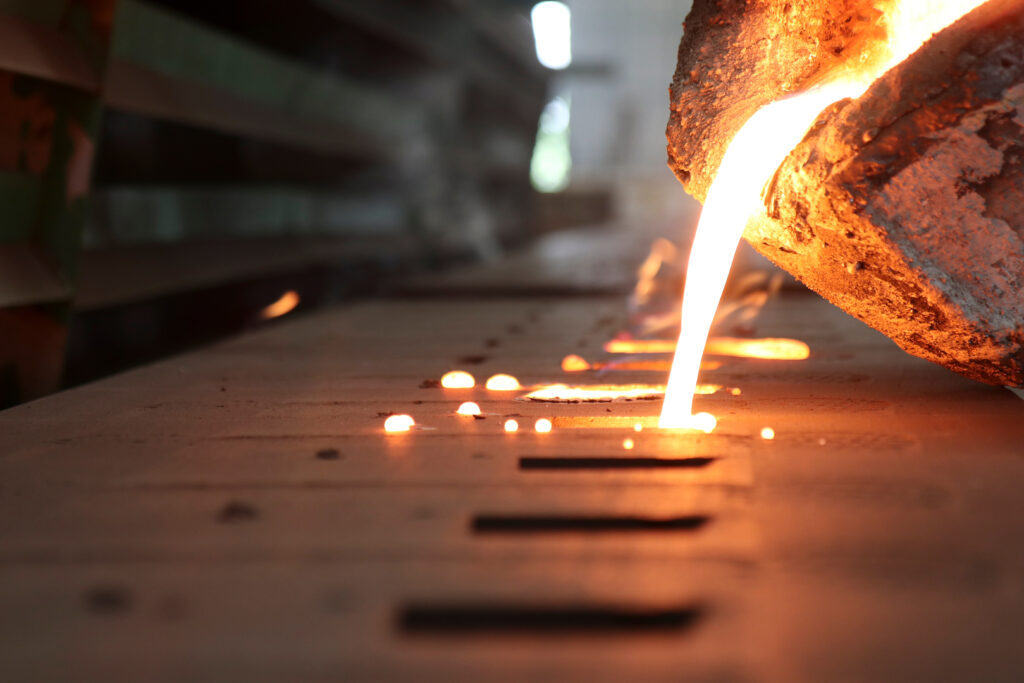 Close up of molten metal being poured into a mold