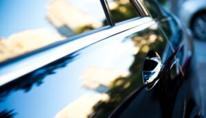 Sunset reflected in close up of car door showing handle