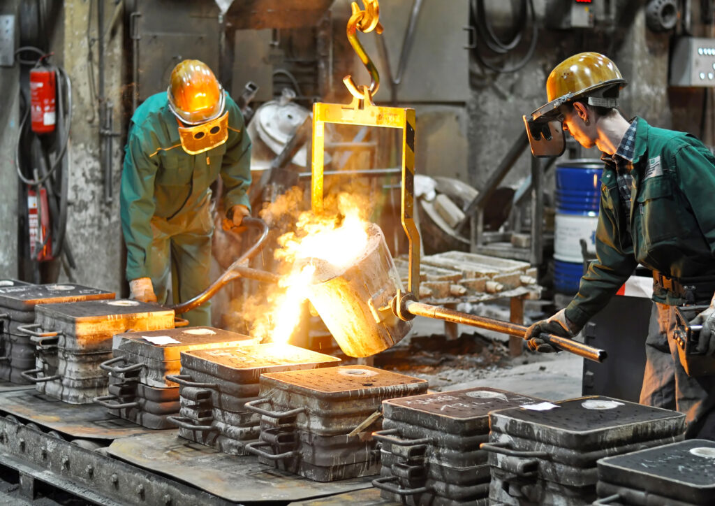 Group of workers in a foundry at the melting furnace