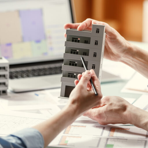 Two architects holding a composite model of a building