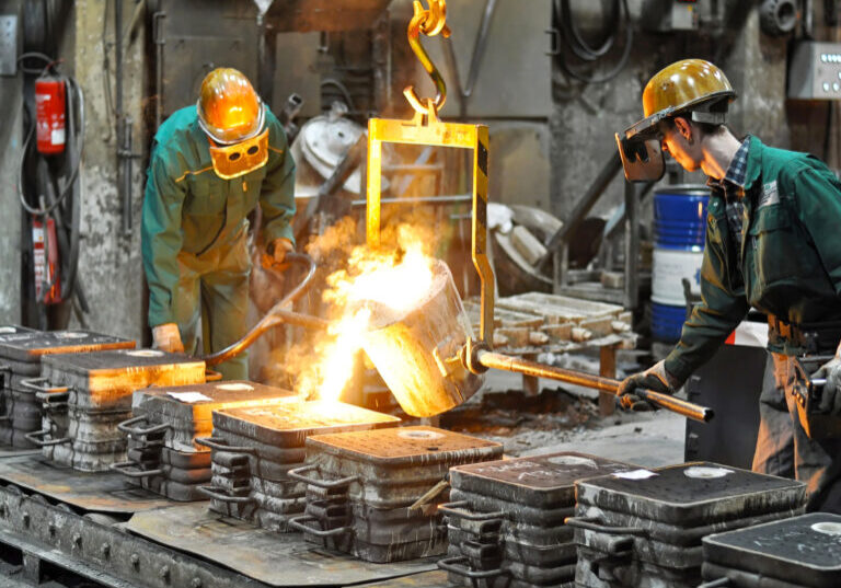 Group of workers in a foundry at the melting furnace