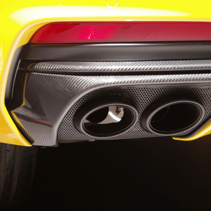 Close up of a yellow car's carbon fibre exhaust pipes