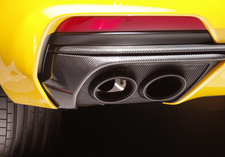 Close up of a yellow car's carbon fibre exhaust pipes